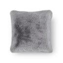 Grey decorative pillow made of luxurious faux fur placed on a modern sofa in a stylish interior