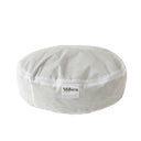 Unique light-colored calming bed for dogs, featuring orthopedic filling and soft eco-fur. The oval design offers coziness and reduces stress effectively.